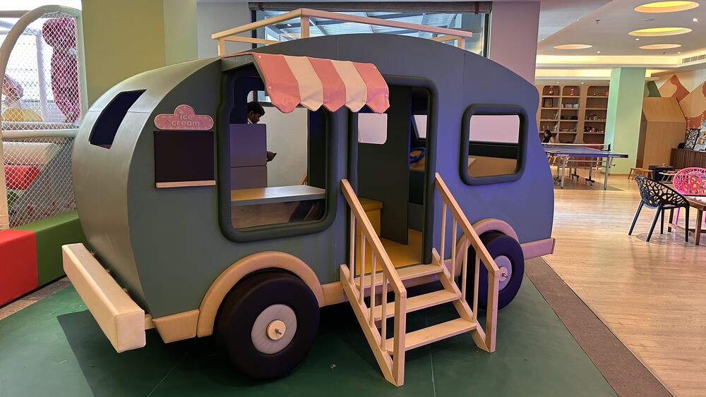 Wooden caravan play house with a striped awning